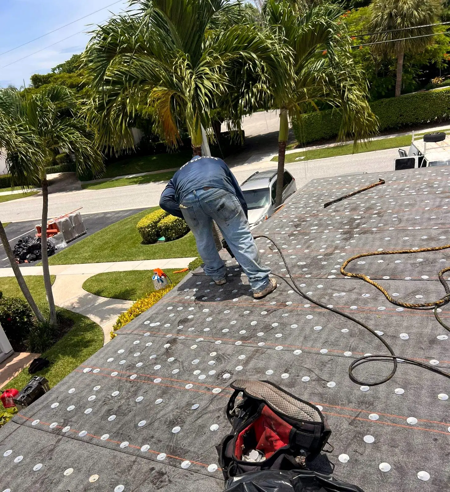PSR crew member fastening underlayment on a roof