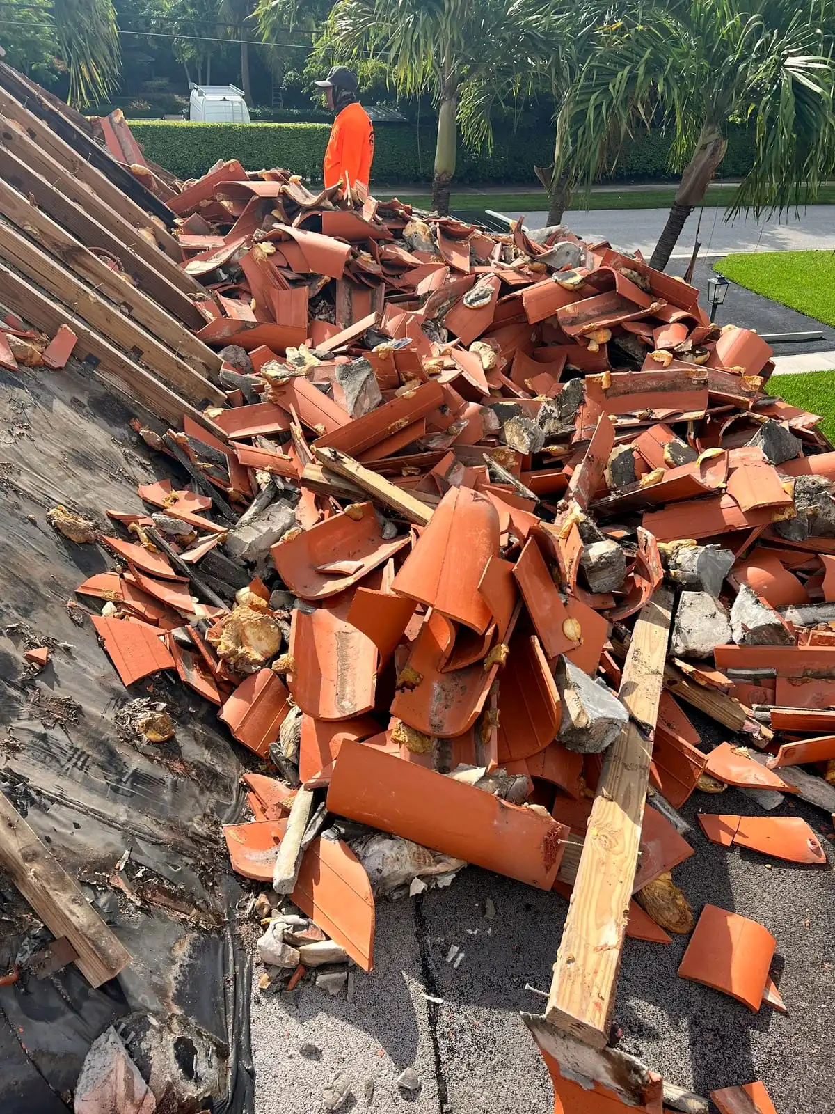 Broken clay tile and battens piled on a roof during a tear-off